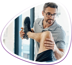 Massage therapist helps client move leg