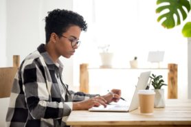 A student uses a laptop to apply for a healthcare job. 