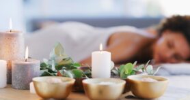 Candles and other decor set up around massage client to create low-stress environment 