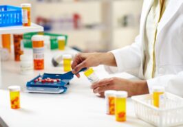 Pharmacy technician putting pills in bottle