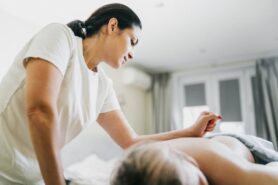 Person receiving back massage and skin treatment