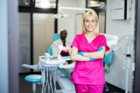 Dental assistant smiling with folded arms in a modern dental clinic