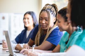 Healthcare students in class with laptop on table