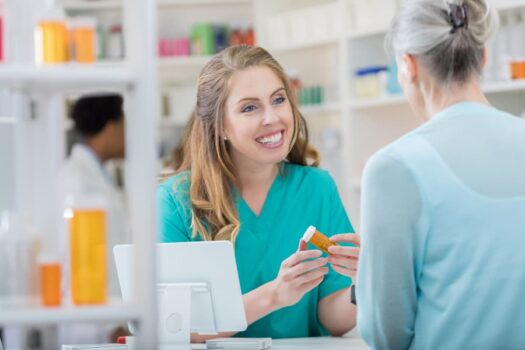 Young nurse counsels senior customer in pharmacy